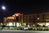 Street view of the the Hampton Inn with a parking lot full of cars on a clear night in Minneapolis, Minnesota.
