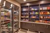 A mini-grocery complete with shelves full of snacks and two refrigerators full of drinks at Hampton Inn Salt Lake City Downtown.