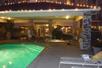 The outdoor pool, hot tub, and patio area at the Hampton Inn Ukiah at night with the lights on.