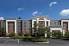 Wide shot of the front exterior of the Hampton Inn & Suites Columbus-Easton Area with a blue cloudy sky above it.