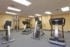 A fitness center with two treadmills, an elliptical, a stationary bike and a weight machine in the background at the Hampton Inn & Suites New Braunfels.
