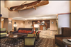 Lobby with soft seating and a hanging wooden boat decoration.