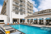 Outdoor pool with sun loungers at Hilton Garden Inn Cocoa Beach-Oceanfront, FL.