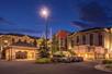 The exterior of the Hilton Garden Inn Salt Lake City Downtown at night and ample outdoor parking spaces and clouds in the sky.