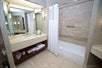 Private bathroom with bath tub and vanity mirror.