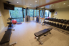 Spacious fitness facility with flat-screen TV  and big mirrors.
