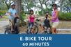 amily riding e-bikes and a blue banner saying "E-Bike Tour 60 Minutes" with Historic Savannah Segway/E-Bike Tour in Savannah, Georgia, USA.