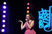 Woman wears a pink dress while singing during Hit Parade at The Grand Majestic Theater