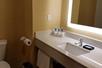 The bathroom features a sink, fresh towels, and complimentary toiletries.