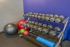 A free weights set with exercise balls around in front of a purple wall in the fitness center at the Holiday Inn Express Columbus Airport – Easton.