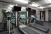 Fitness room with two treadmills, elliptical machine and a stationary bicycle.