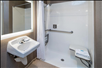 Accessible bathroom with roll-in shower and a folding shower bench.