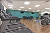 Spacious fitness room with cardio equipment and free weights.