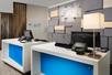 Two white and blue front desks with computers on them and a geometric accent wall behind them at the Holiday Inn Express & Suites New Braunfels.