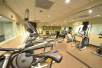 Fitness center with treadmills, elliptical trainer, free weights, and other gym equipment.