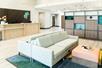 A lounge area with light gray couches and a front desk in the lobby of the Holiday Inn & Suites Orlando Int'l Drive South.