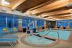 Refreshing indoor heated pool with poolside chairs and pool lift.