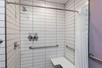 Comfort meets accessibility in this roll-in shower inside a private bathroom.