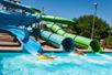 The Bonzai Pipeline featuring three slides from a four-story tower with two people in tubes splashing into the water.