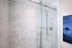 Shower with a glass enclosure in a private bathroom.