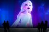 A a projection of Elsa from Disney's "Frozen" with silhouetted spectators gathered in awe to view the display.