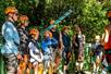 A group of people listening to their instructor as they are about to try out the jungle zip line experience.