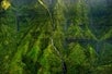 Several waterfalls flowing down a vegetated cliffside on the Kauai Eco Adventure Helicopter Tour in Hawaii USA.