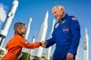 A young boy shakes the hand of an astronaut