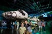 Boys take a picture in front of the Atlantis space shuttle