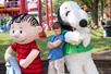 A young boy posing with Snoopy and Linus at King's Island in Cincinnati, Ohio.