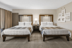 Two double beds in a well-appointed guest room.