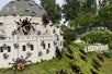 A large Lego structure at Legoland California, adorned with numerous intricately designed Lego spiders crawling over the building and surrounding grass