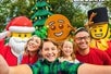 Legoland Santa, Gingerbread Man, Toy Soldier, and family of four taking a selfie in front of the Christmas tree.