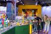 Two parents and two children looking at a large city full of buildings and cars entirely made out of LEGO at LEGOLAND® Discovery Center Atlanta.
