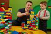 An adult and child build a masterpiece with LEGO bricks from a large bin at LEGOLAND Discovery Center Columbus.