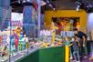 Two parents and two children looking at a large city full of buildings and cars entirely made out of LEGO at LEGO Discovery Center Boston.