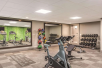 Fitness center with exercise bike, free weights, and other gym equipment.