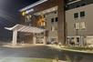 The front exterior of the La Quinta Inn & Suites by Wyndham Valdosta with a covered entrance on a clear night.