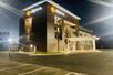 The front and side exterior of the La Quinta Inn & Suites by Wyndham Valdosta with a covered entrance on a clear night.