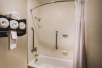 Fresh towels, and shower and tub with grab bars in an accessible guest bathroom.