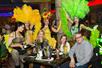Some of the dancers with feathers taking a picture with some guests at their table at Mango's Tropical Café for Mango's Live! in Orlando Florida, USA.