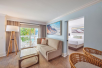 A king suite with a separate living area with sofa bed, balcony and resort/garden view at Margaritaville Beach House Key West, FL.
