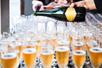 Rows and rows of champagne glasses with a bartender pouring more glasses on the Hornblower Marina del Rey Sights & Sips Cruise.