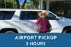 A woman in a big hat smiling in front of a white SUV and a box saying "Airport Pickup 2 Hours" with Maui Pickup in Maui, Hawaii, USA.