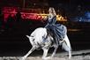 A maiden rides a white horse that is bowing