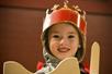 A child is dressed as a knight with a Medieval Times sword and shield