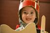 A child dresses up with a crown, sword, and shield