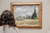 A woman looking at a painting of some landscape of trees on the Meet the Met: Metropolitan Museum of Art Tour in New York City, New York, USA.