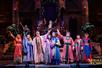 Jubilant cast in colorful costumes live on stage at the Miracle of Christmas show.