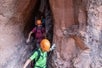 The tour group coming through this tight space in the chasm they just rappeled in on the Moab Canyoneering Adventure Moab Utah.